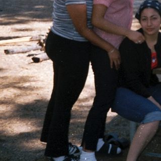 Family group photo outdoors in park setting.