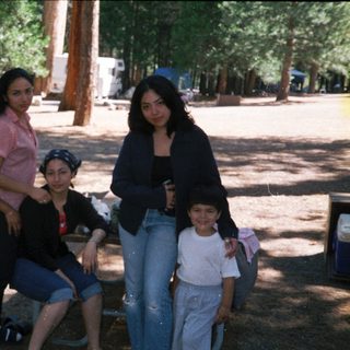 Family group photo outdoors in park setting.