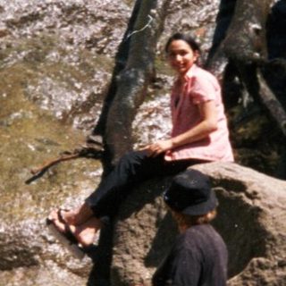 People exploring rocky waterfall area outdoors.