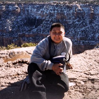 Person sitting on Grand Canyon rim.