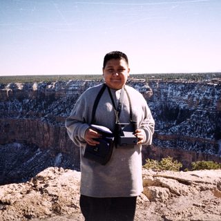 Person holding camera at Grand Canyon viewpoint.