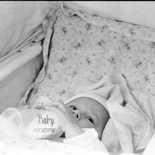 Baby sleeping in heat-resistant bassinet.