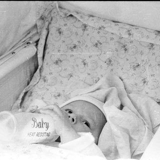 Baby sleeping in heat-resistant bassinet.