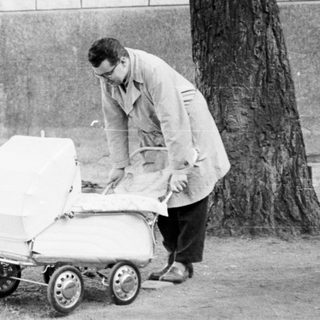 Man pushing baby stroller near waterfront.