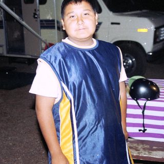 Boy in sports jacket standing near RV campground.