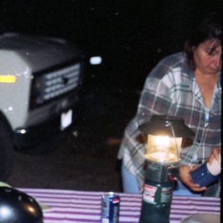 Boy in sports jacket standing near RV campground.