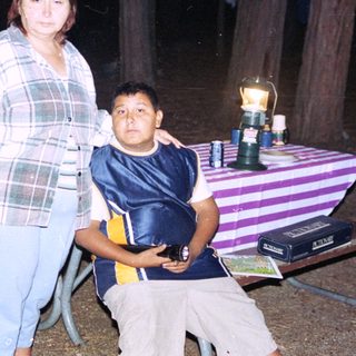 Family posing outdoors at night near a table.
