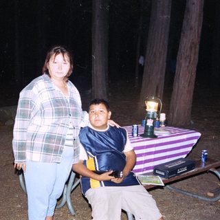 Family posing outdoors at night near a table.