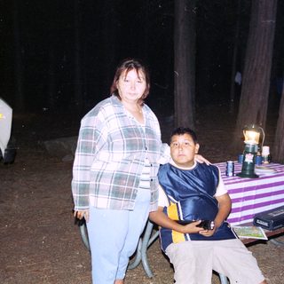 Family posing outdoors at night near a table.