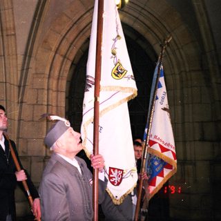 Veterans holding flags during commemorative ceremony.