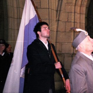 Veterans holding flags during commemorative ceremony.