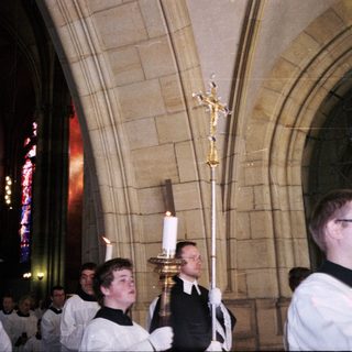 Religious procession with clergy holding candles.
