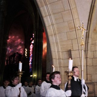 Religious procession with clergy holding candles.