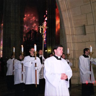 Religious procession with clergy carrying candles.