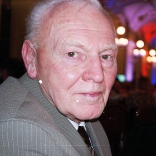 Elderly man in formal attire at evening event.