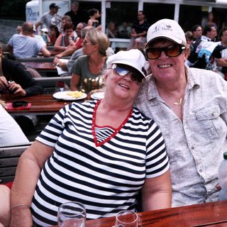 Happy couple enjoying boat river outing with friends.