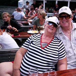 Happy couple enjoying boat river outing with friends.
