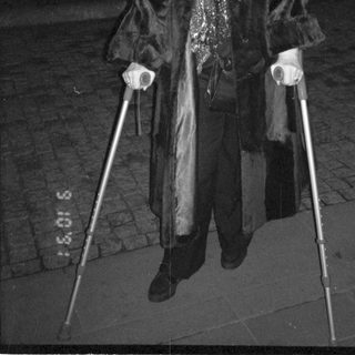 Person using walking poles in winter coat at night.