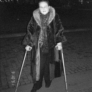 Person using walking poles in winter coat at night.