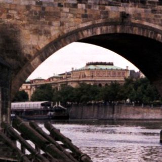 Historic stone bridge with statues over river.