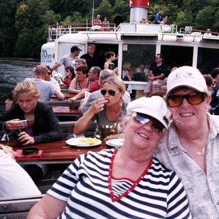 Boat tour with happy passengers enjoying river cruise.