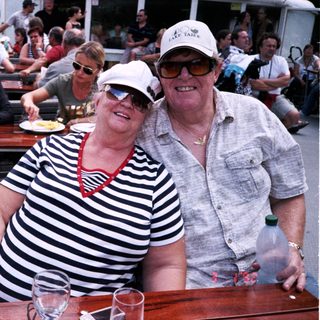 Happy couple enjoying boat river outing with drinks.