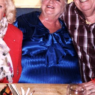 Three people smiling together indoors.