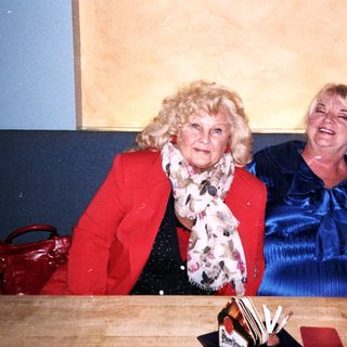 Three people smiling together indoors.