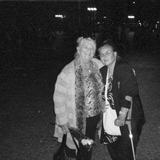 Two women smiling together at night event.