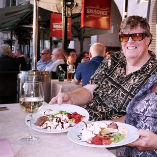 Two women enjoying meal outdoors at café.
