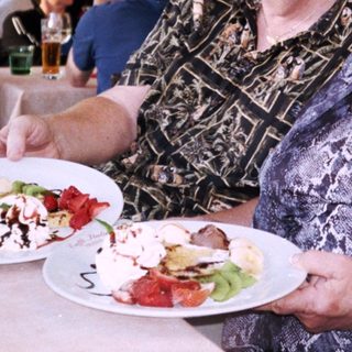 Two women enjoying meal outdoors at café.