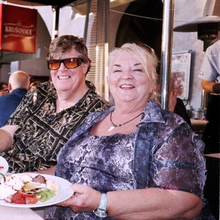 Two women enjoying meal outdoors at café.
