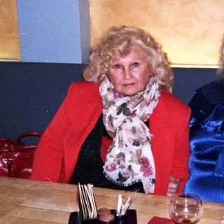 Three adults smiling together indoors at a table.