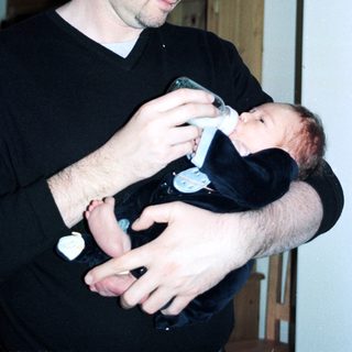 Man holding baby during bottle feeding.