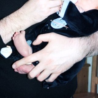 Man holding baby during bottle feeding.