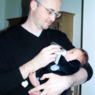 Man holding baby during bottle feeding.