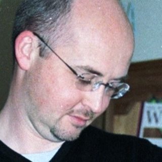 Man holding newborn baby indoors.