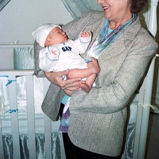 A woman holding a newborn baby indoors.