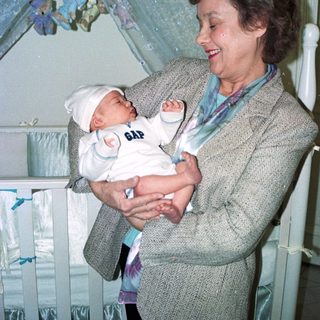 A woman holding a newborn baby indoors.