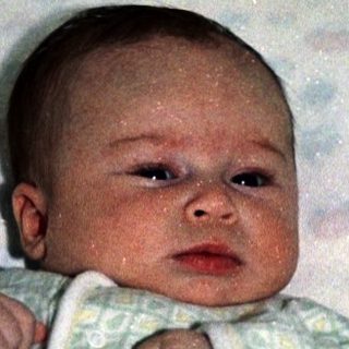 Baby in a portable bassinet or travel crib.
