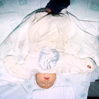 Newborn baby wrapped in a white blanket.
