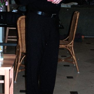 Man holding baby in formal dining room.