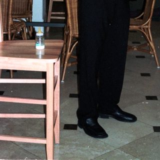 Man holding baby in formal dining room.