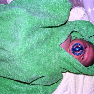 Newborn infant wearing medical eye shield.