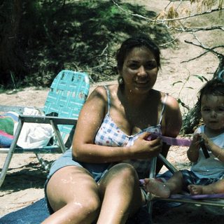 Mother and child relaxing by water.