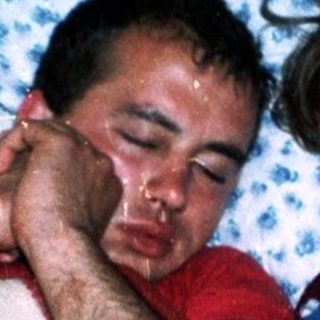 Two people resting together under blankets.