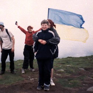 People hiking in misty terrain with flag.