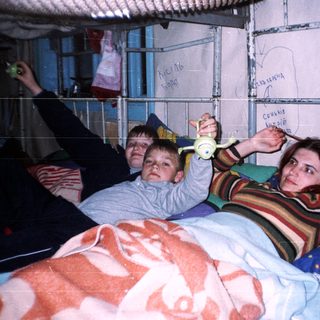Family playing with hula hoops indoors.