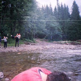 People playing frisbee by a river.