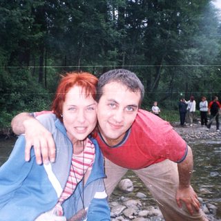 Two people posing happily by a river.